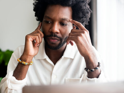 Contemplative Individual in White Shirt Sitting Indoors 
