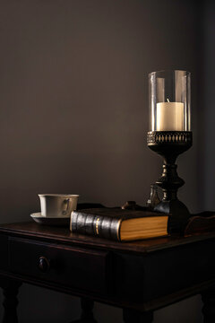 Still life of a vintage candle, book and cup