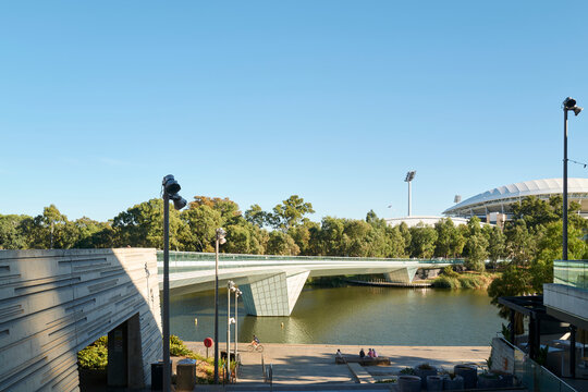 Scenic river view with modern bridge and stadium backdrop
