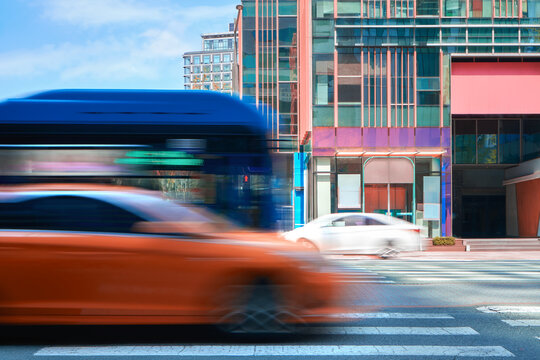 Busy urban street with vehicles in motion near modern buildings