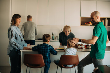 Family members gathered in kitchen with children