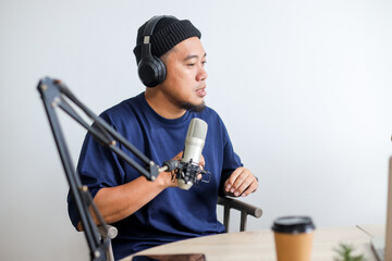 Mature Male Podcaster Speaking into a Microphone in a Recording Studio