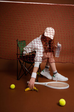 Girl picking Banana behind Net 