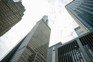 Skyscrapers of glass and metal rise tightly packed in New York's Midtown. This dense corridor reflects modern business, investment, and architecture.