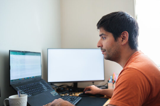 Remote worker man using a laptop and desktop computer