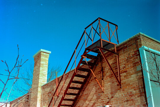 Fire escape and chimney against saturated sky