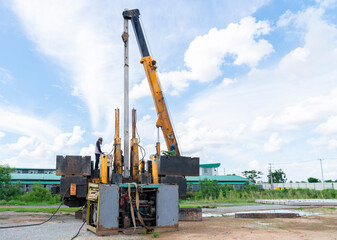 Workers install pile driving by hydraulic static pile driver machine.