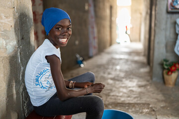 Smiling young senegalese girl sitting in a corridor in Africa