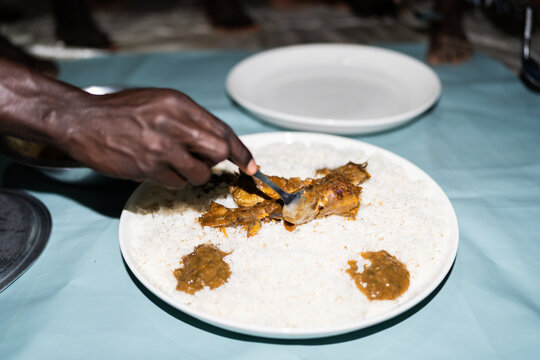 Chef preparing traditional Senegalese ceebu jen, dish with rice