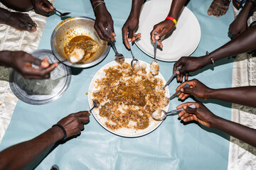 Senegalese people sharing traditional thieboudienne