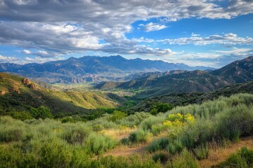 Fototapeta premium Dramatic mountains rise above verdant valleys under a vibrant sky filled with clouds, Dramatic mountains