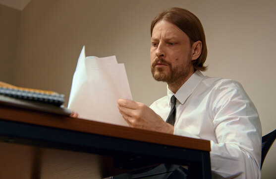 Office worker reading important documents at desk