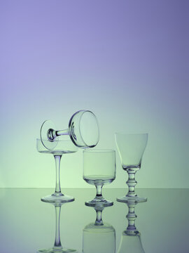 Elegant glassware is stacked in an artistic arrangement on a gradient