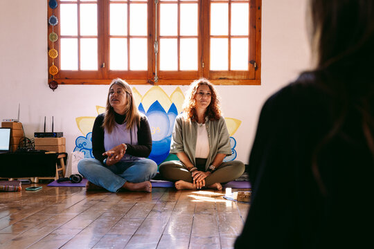 Yoga teachers explaining meditation techniques in studio