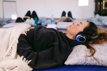 Woman relaxing with headphones during guided meditation session