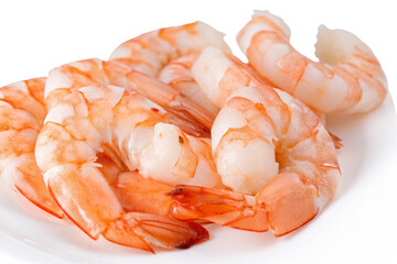 A close up view of a pile of cooked shrimp on a white plate against a black and white background