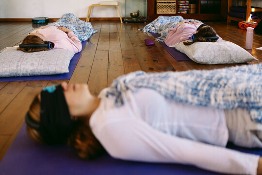 Women relaxing and breathing during guided meditation session