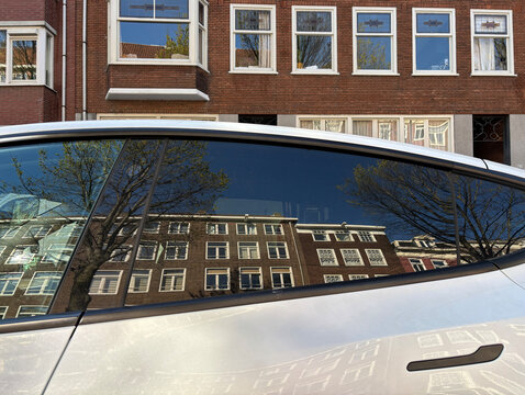 facade of building reflected in car window