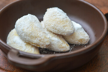 close up of snow white cookies in bowl on wooden table