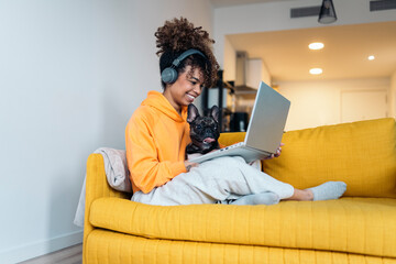 Freelancer working from home with her french bulldog on the sofa