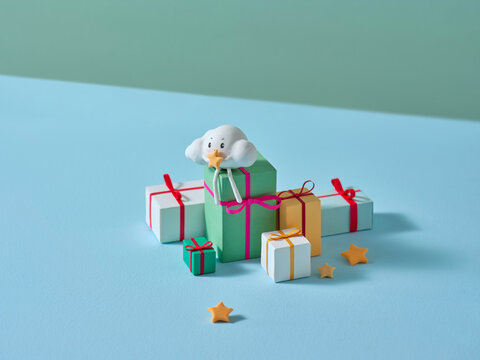 A charming cloud character sits amongst the colorful gift boxes