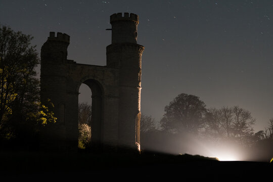 A ruined folly in the countryside at night