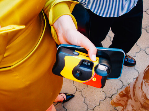 Multicolor disposable camera next to phone