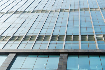 A beautiful background of an glass office building, reflecting clouds in the opened windows