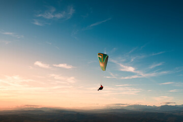 Paraglider freedom flying on sunset sky 