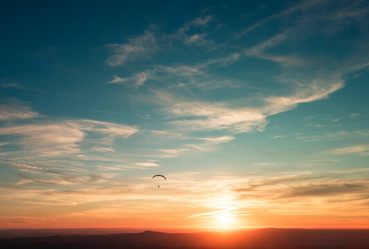 Paraglider daydream flight at sunset