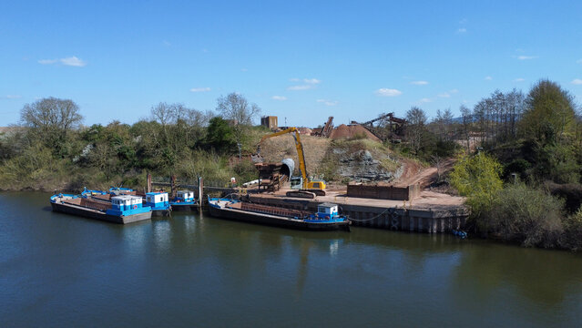 Empty barges on a river next to a sand and gravel processing site