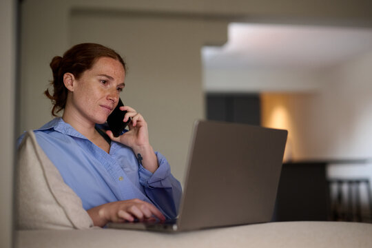 Pregnant Woman on Phone Call at Home While Working with her laptop