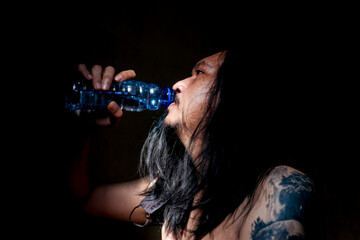 A man gulps down a plastic bottle of mineral water
