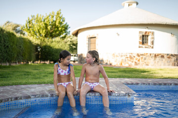 Siblings sitting by the pool talking