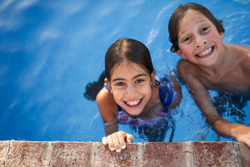 portrait of siblings in the pool