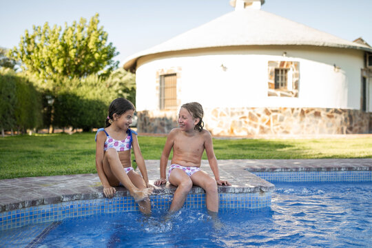 Siblings sitting by the pool talking