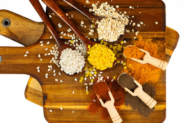A Colorful Assortment of Various Spices and Grains Uniquely Arranged on a Wooden Board