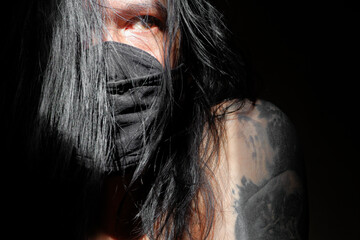 Depressed Long-Haired Man with Tattoo in Dark Emotional Portrait