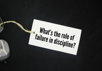 Glasses and paper tags with the question words What’s the role of failure in discipline?