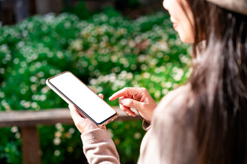 Young female using mobile phone and relaxing in the garden, Modern lifestyle