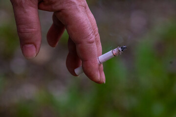 Hand holding a cigarette. Addiction concept. High quality photo