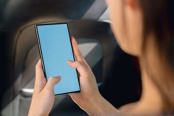 Woman sitting in a private car and hand holding smartphone mockup of blank screen, Take your screen to put on advertising