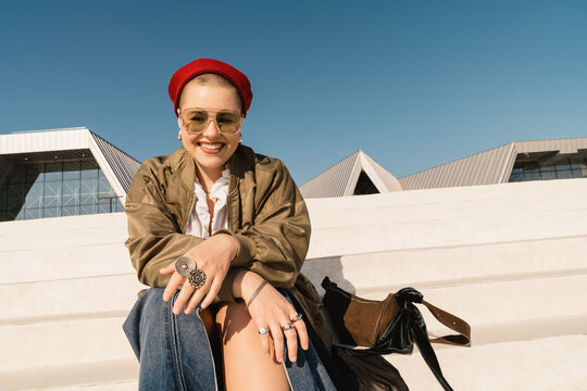 Smiling person in sailor-style hat sitting outdoors