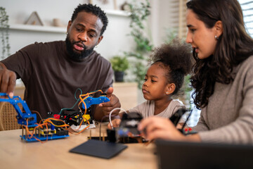 African love family, father mother and daughter learning STEM education, science experiment, robotics toy, technology and innovation interactive learning, creativity and development at home