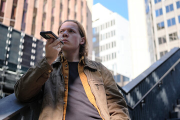 Young man using smartphone in urban setting in Melbourne