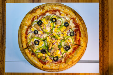 Vegetarian pizza with corn, zucchini, mushrooms, onions, and olives