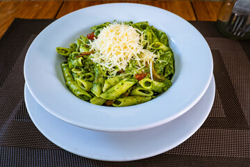 Short pasta with pesto, Parmesan cheese, and tomato