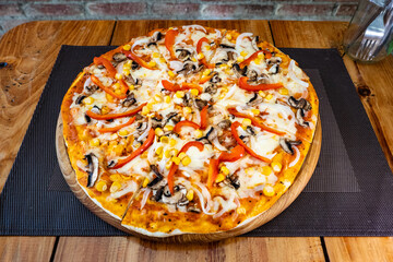 Vegetarian pizza with corn, mushrooms, peppers, and onions