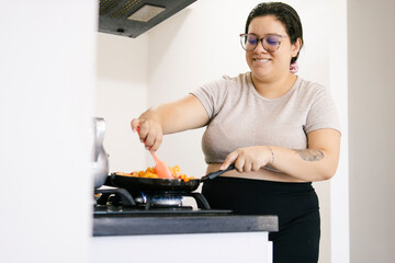 Colombian woman cooking a family meal in modern kitchen