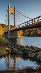 Fototapeta premium Suspension Bridge at Sunset: A majestic suspension bridge stretches across a serene river at sunset, its reflection shimmering in the calm water.